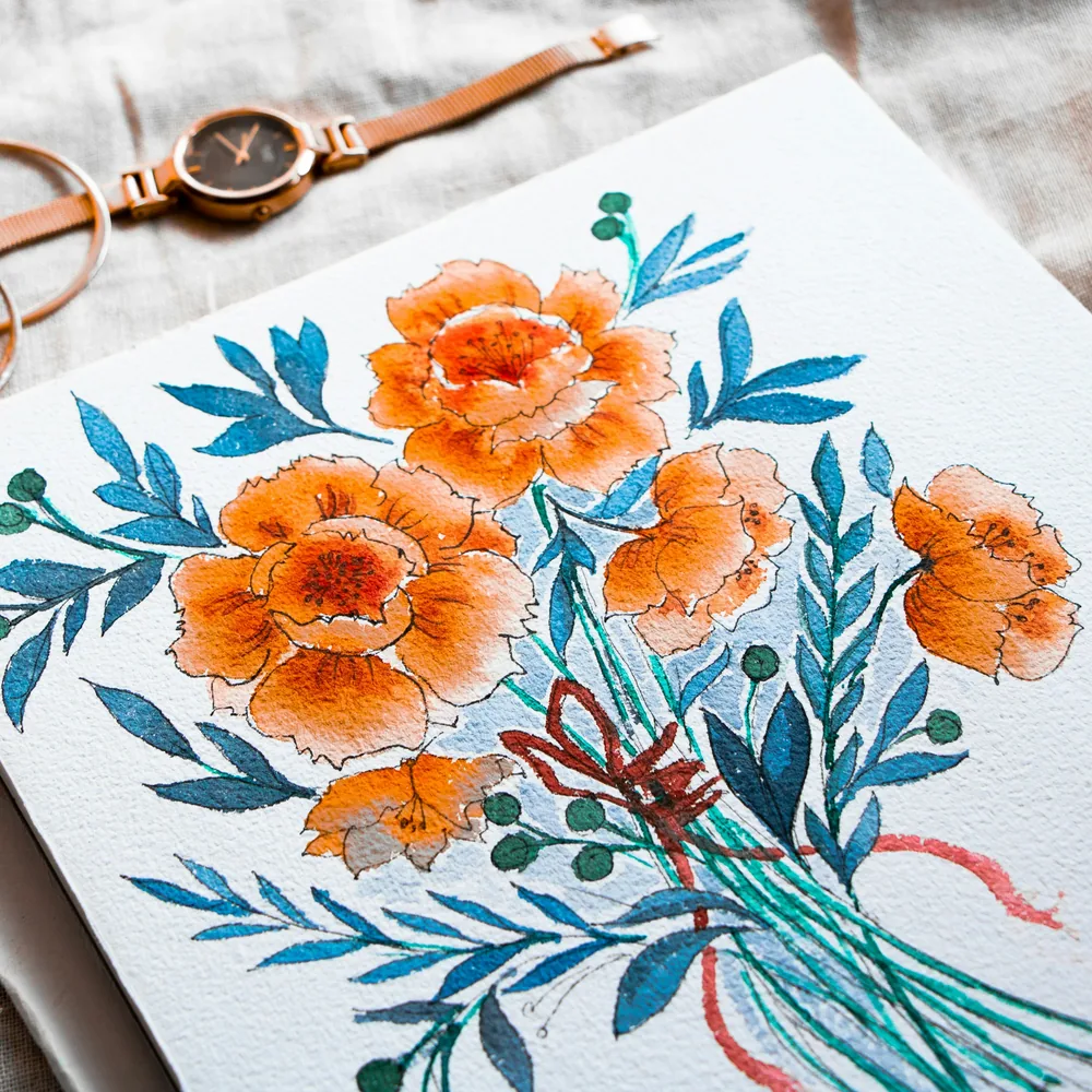 Tavola ad acquerello con fiori arancioni e foglie azzurre, contorni ripassati a china su carta ruvida